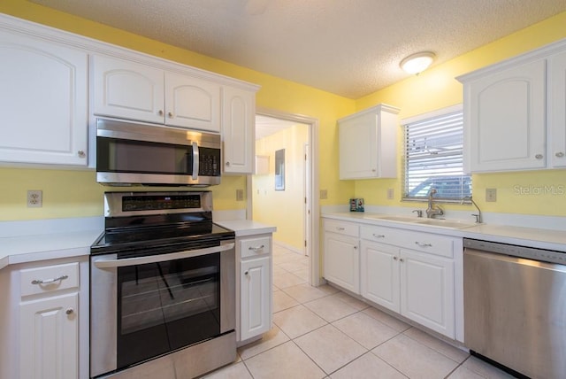 106 Silverbell Ct, Sun City Center, FL 33573 - kitchen with appliances with stainless steel finishes, a sink, white cabinetry, and a textured ceiling