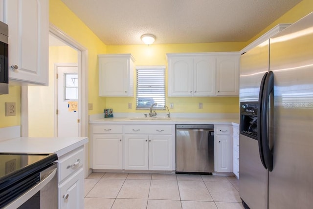 106 Silverbell Ct, Sun City Center, FL 33573 - kitchen with stainless steel appliances, a sink, white cabinetry, light tile patterned floors, and light countertops