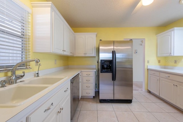 106 Silverbell Ct, Sun City Center, FL 33573 - kitchen with stainless steel fridge, a sink, dishwasher, white cabinetry, and light countertops