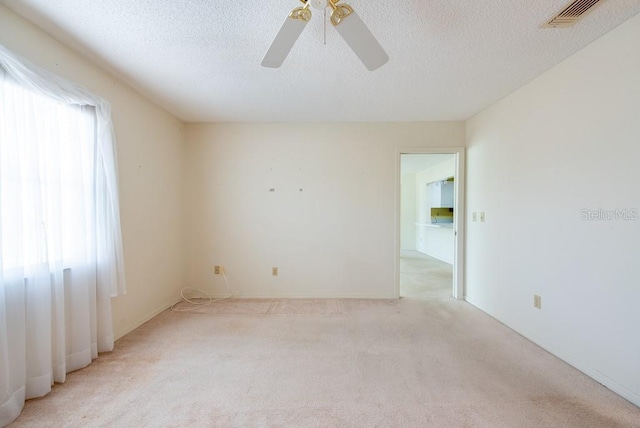 106 Silverbell Ct, Sun City Center, FL 33573 - unfurnished room with light colored carpet, a ceiling fan, and a textured ceiling