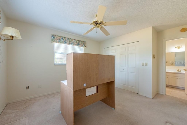 106 Silverbell Ct, Sun City Center, FL 33573 - unfurnished bedroom with light carpet, a closet, a ceiling fan, baseboards, and a textured ceiling