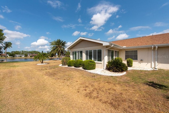 106 Silverbell Ct, Sun City Center, FL 33573 - rear view of house with a water view, a lawn, and stucco siding