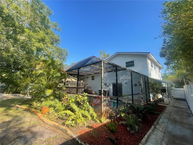 6073 115th Ave N, Pinellas Park, FL 33782 - view of side of property featuring an outdoor pool, glass enclosure, a deck, and a patio area