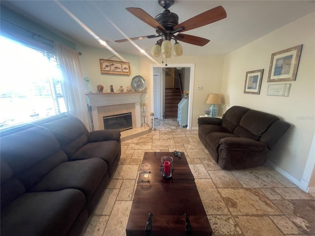 6073 115th Ave N, Pinellas Park, FL 33782 - living room with stone tile flooring, a ceiling fan, baseboards, stairs, and a fireplace with raised hearth