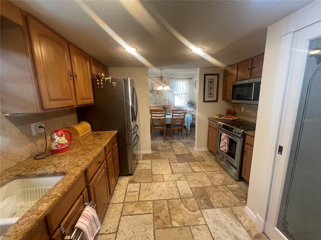 6073 115th Ave N, Pinellas Park, FL 33782 - kitchen with appliances with stainless steel finishes, stone tile floors, brown cabinets, backsplash, and a sink