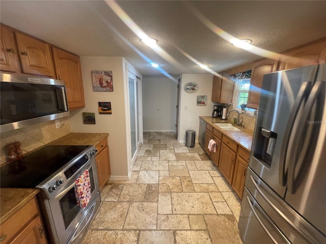 6073 115th Ave N, Pinellas Park, FL 33782 - kitchen with stainless steel appliances, a sink, stone tile floors, backsplash, and a textured ceiling