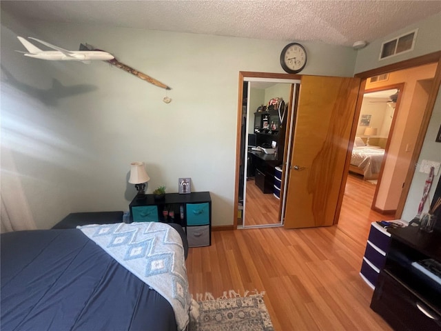 6073 115th Ave N, Pinellas Park, FL 33782 - bedroom with light wood-type flooring and a textured ceiling