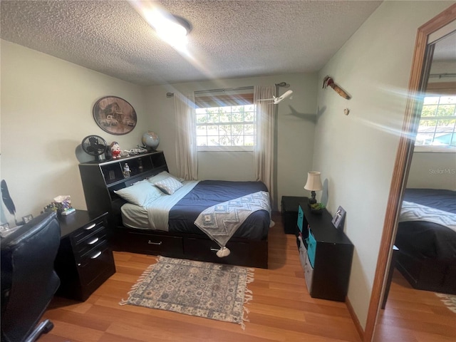 6073 115th Ave N, Pinellas Park, FL 33782 - bedroom featuring a textured ceiling, light wood-style flooring, and multiple windows