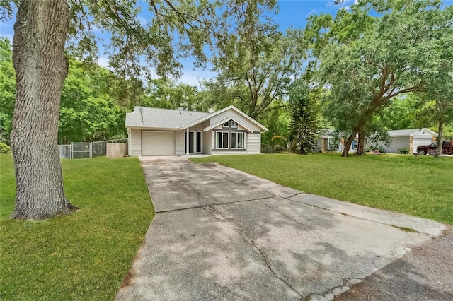 view of front of house with an attached garage, concrete driveway, and view of scattered trees