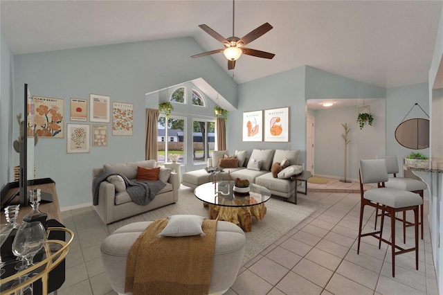 living area with high vaulted ceiling, ceiling fan, light tile patterned flooring, and baseboards
