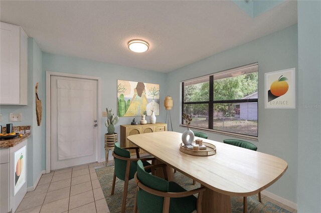 dining space with light tile patterned flooring and baseboards