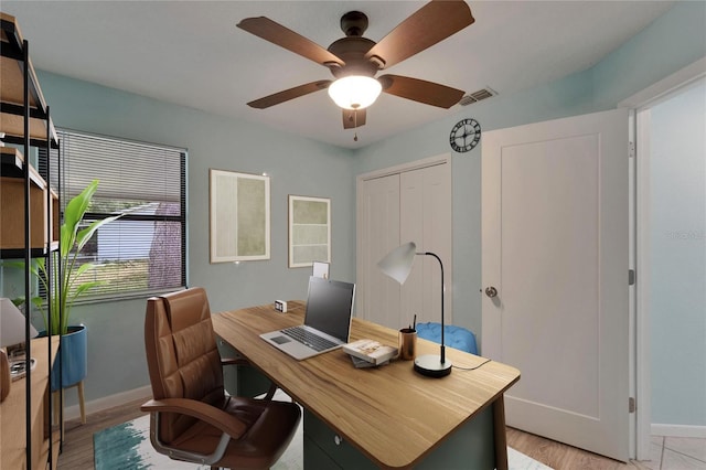 home office with baseboards, a ceiling fan, and light wood-style flooring