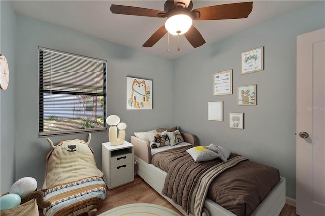 bedroom with light wood-style floors and a ceiling fan