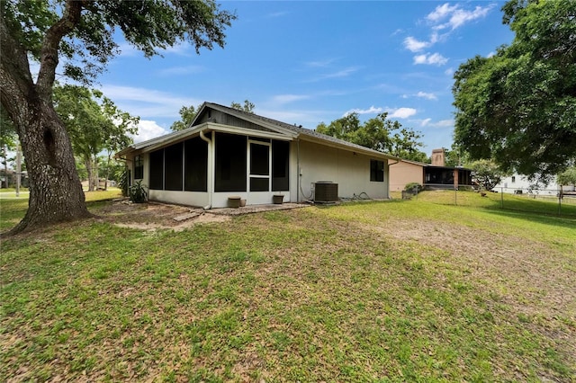 rear view of house with a sunroom and central air condition unit