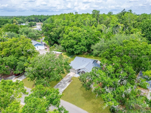 aerial view of property and surrounding area featuring a heavily wooded area