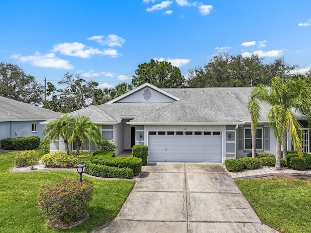 2413 Oxford Down Ct Unit 58, Sun City Center, FL 33573 - ranch-style home featuring an attached garage, a front yard, concrete driveway, and roof with shingles