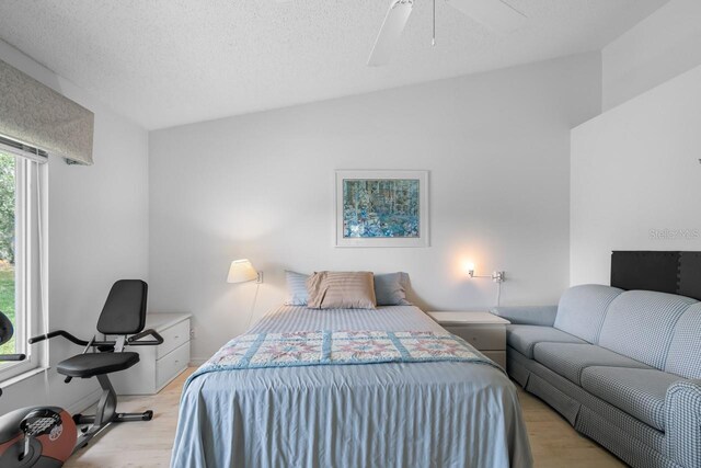 2413 Oxford Down Ct Unit 58, Sun City Center, FL 33573 - bedroom with light wood-style flooring, ceiling fan, and a textured ceiling