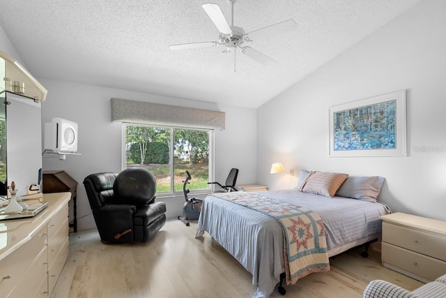 2413 Oxford Down Ct Unit 58, Sun City Center, FL 33573 - bedroom featuring light wood-type flooring, a textured ceiling, vaulted ceiling, and a ceiling fan
