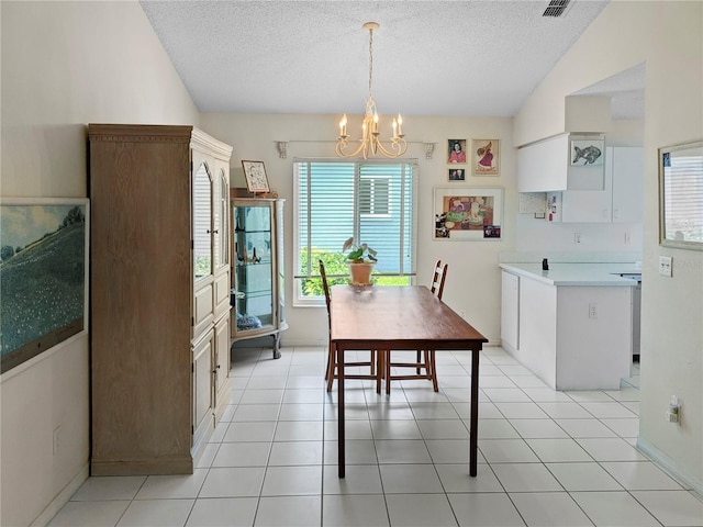 2413 Oxford Down Ct Unit 58, Sun City Center, FL 33573 - dining area with a chandelier, a textured ceiling, vaulted ceiling, baseboards, and light tile patterned flooring