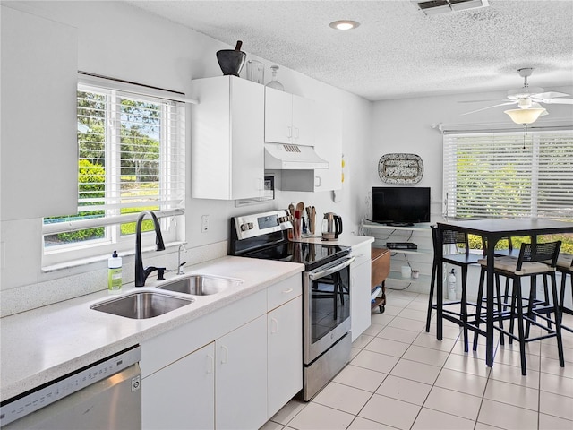 2413 Oxford Down Ct Unit 58, Sun City Center, FL 33573 - kitchen with appliances with stainless steel finishes, under cabinet range hood, a sink, light countertops, and a textured ceiling