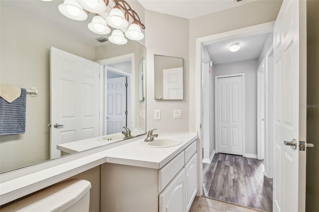 bathroom featuring vanity, toilet, baseboards, and tile patterned flooring