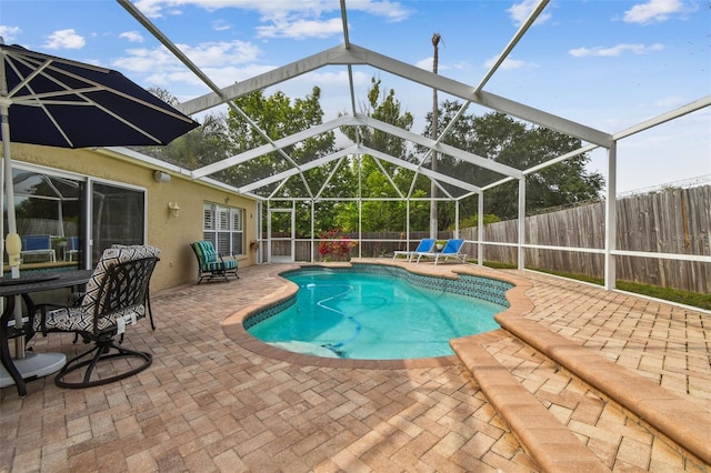 view of swimming pool with a fenced backyard, a patio, and a lanai