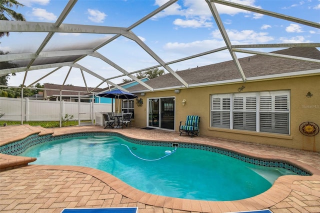 view of pool with a patio, fence, glass enclosure, and outdoor dining area