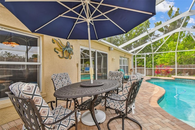 view of swimming pool featuring a patio, fence, and a lanai