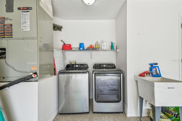 washroom featuring washer and dryer, baseboards, heating unit, and a textured ceiling