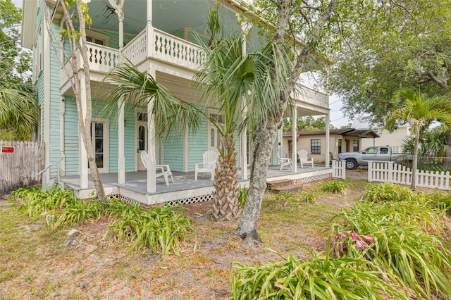 rear view of property with fence and a porch
