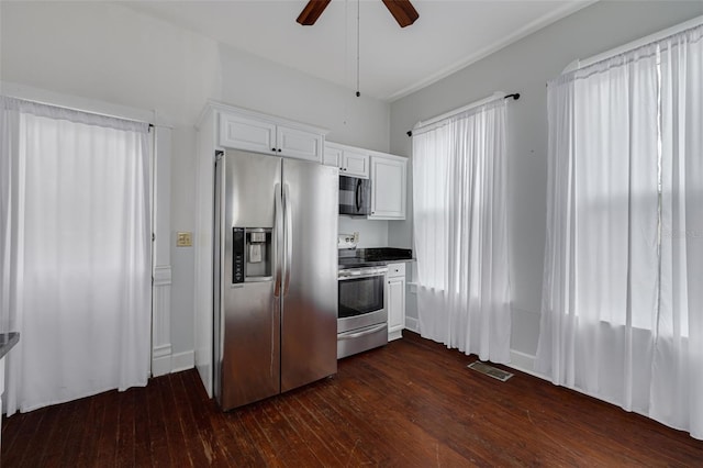 kitchen featuring appliances with stainless steel finishes, dark wood finished floors, white cabinets, a ceiling fan, and dark countertops