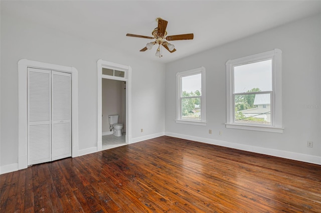 unfurnished bedroom with baseboards, wood-type flooring, ceiling fan, and ensuite bath