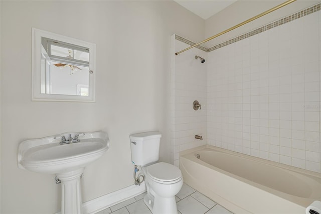bathroom featuring toilet, tile patterned flooring, shower / bath combination, and baseboards