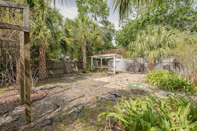 fenced backyard with a storage shed and an outdoor structure
