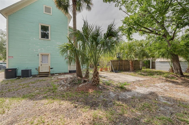 back of house with entry steps, fence, and cooling unit