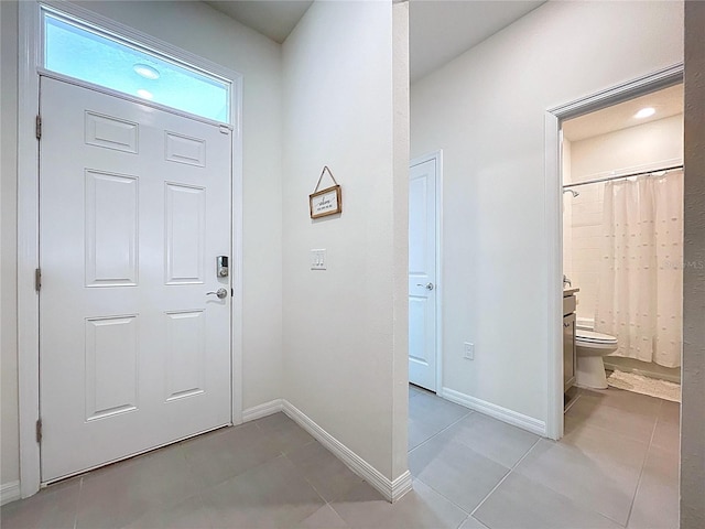 entryway featuring baseboards and light tile patterned flooring