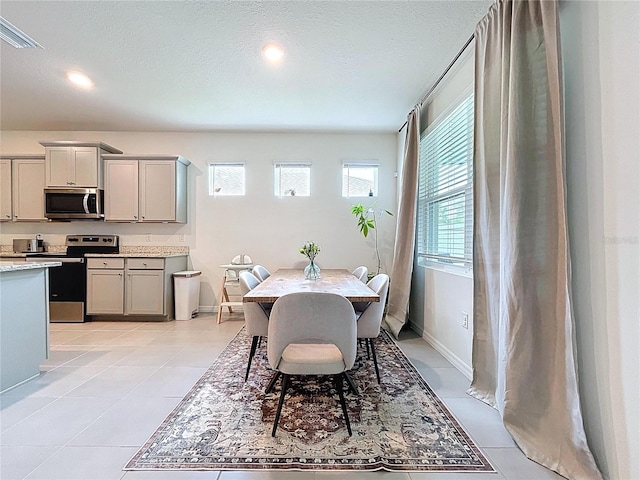 dining space with recessed lighting, baseboards, and light tile patterned flooring