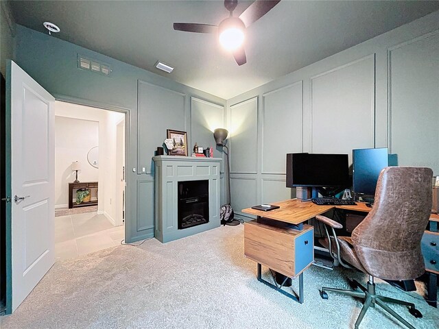 office area with a decorative wall and ceiling fan