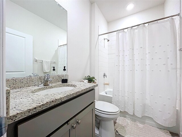bathroom featuring shower / bathtub combination with curtain, toilet, and vanity