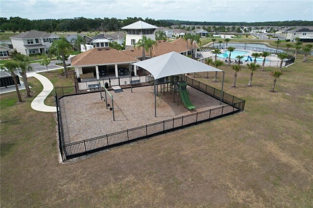 community playground featuring fence and a residential view