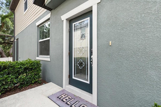 view of exterior entry with stucco siding