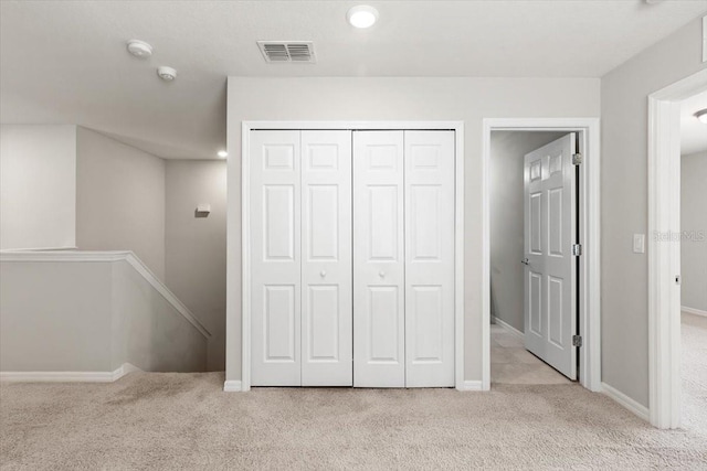 unfurnished bedroom with carpet, a closet, baseboards, and recessed lighting