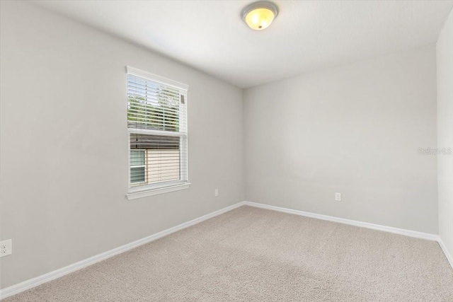 carpeted empty room with baseboards