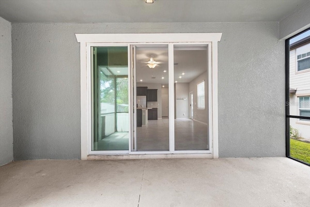 doorway to property featuring stucco siding and a patio area