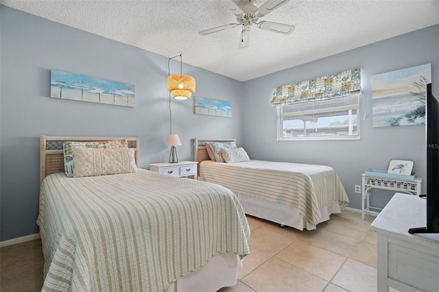bedroom with light tile patterned floors, a textured ceiling, ceiling fan, and baseboards