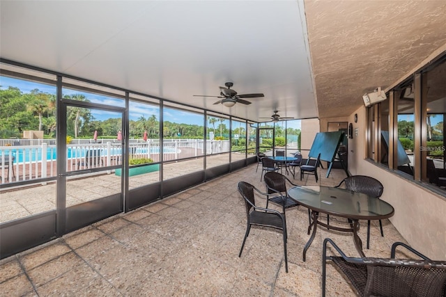 sunroom / solarium featuring a ceiling fan