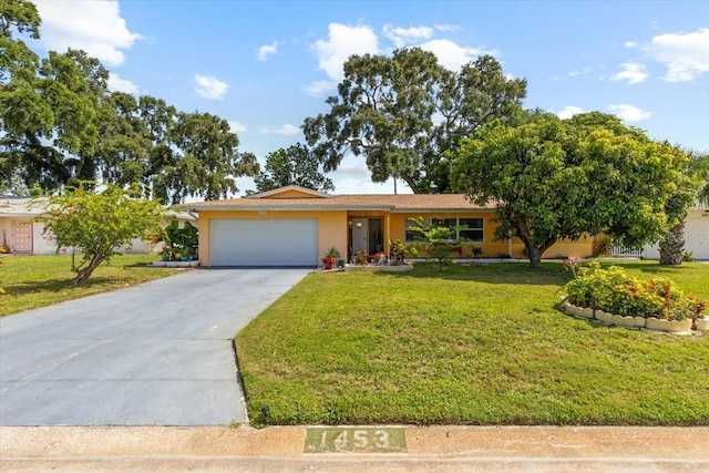 1453 62nd Ter S, Saint Petersburg, FL 33705 - view of front of home with an attached garage, a front yard, driveway, and stucco siding