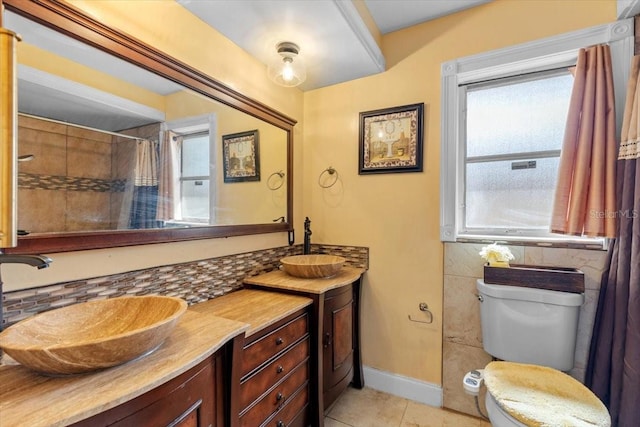 1453 62nd Ter S, Saint Petersburg, FL 33705 - bathroom featuring toilet, double vanity, tile patterned flooring, a shower with curtain, and baseboards