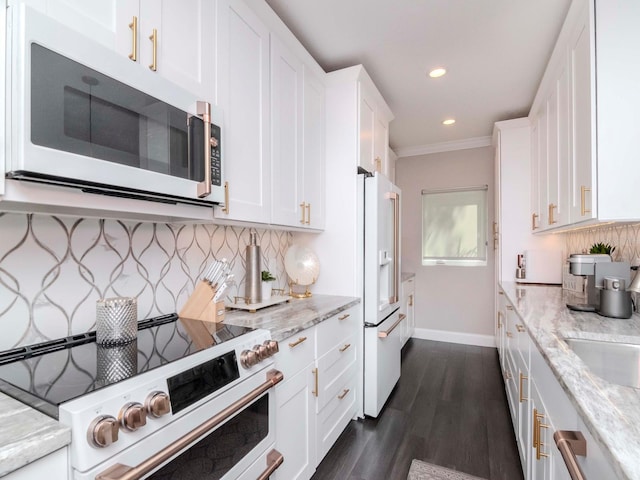 2807 W Hawthorne Rd Unit 11, Tampa, FL 33611 - kitchen with white appliances, baseboards, white cabinets, dark wood finished floors, and ornamental molding
