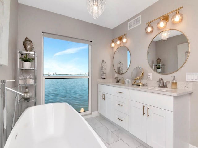 2807 W Hawthorne Rd Unit 11, Tampa, FL 33611 - bathroom with a chandelier, a freestanding tub, double vanity, and a water view